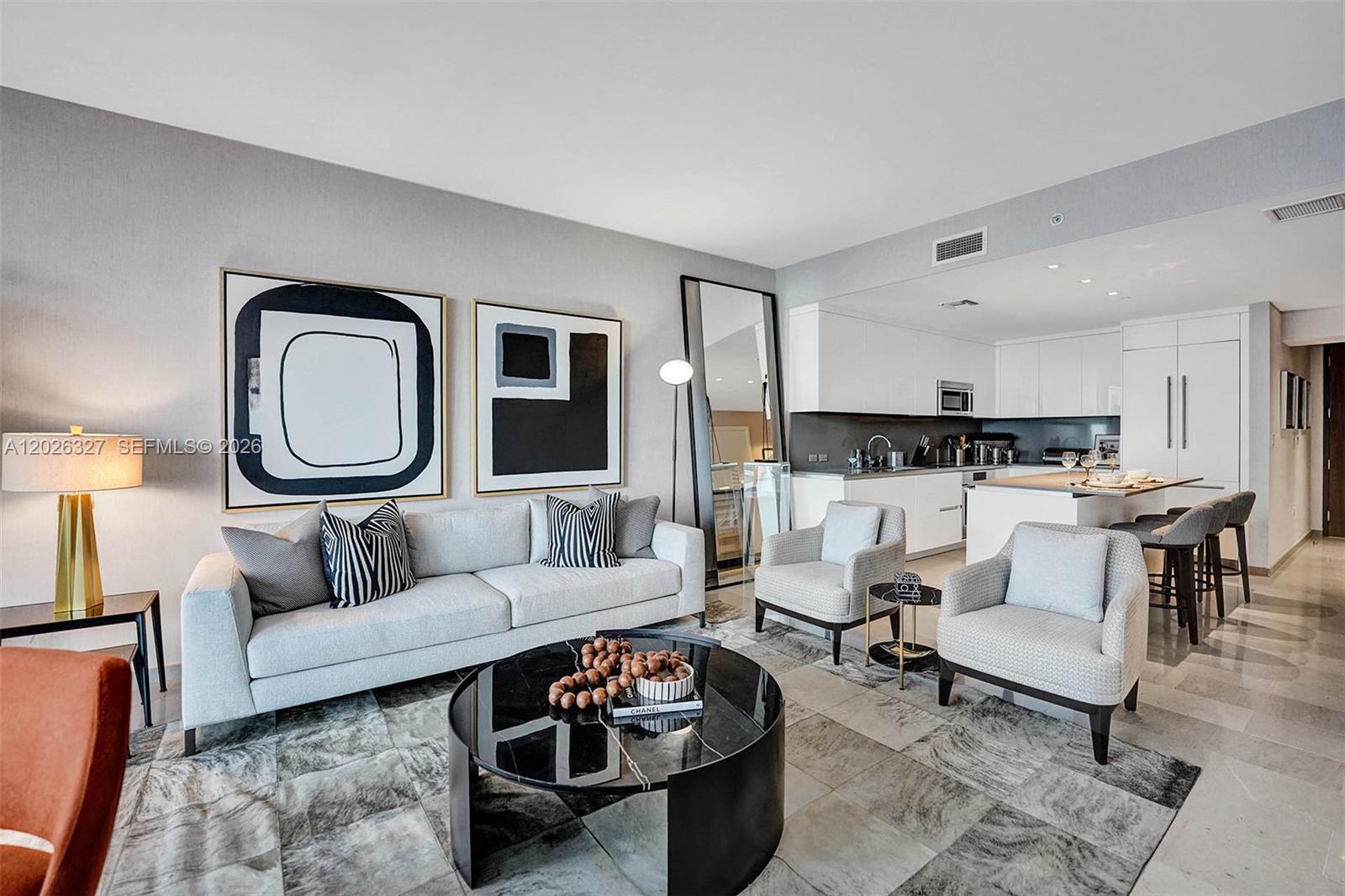 A modern living room features a sofa, two armchairs, a coffee table, and an open kitchen — 88 SW 7th St # 1408, Miami FL 33130, MIAMI, FL