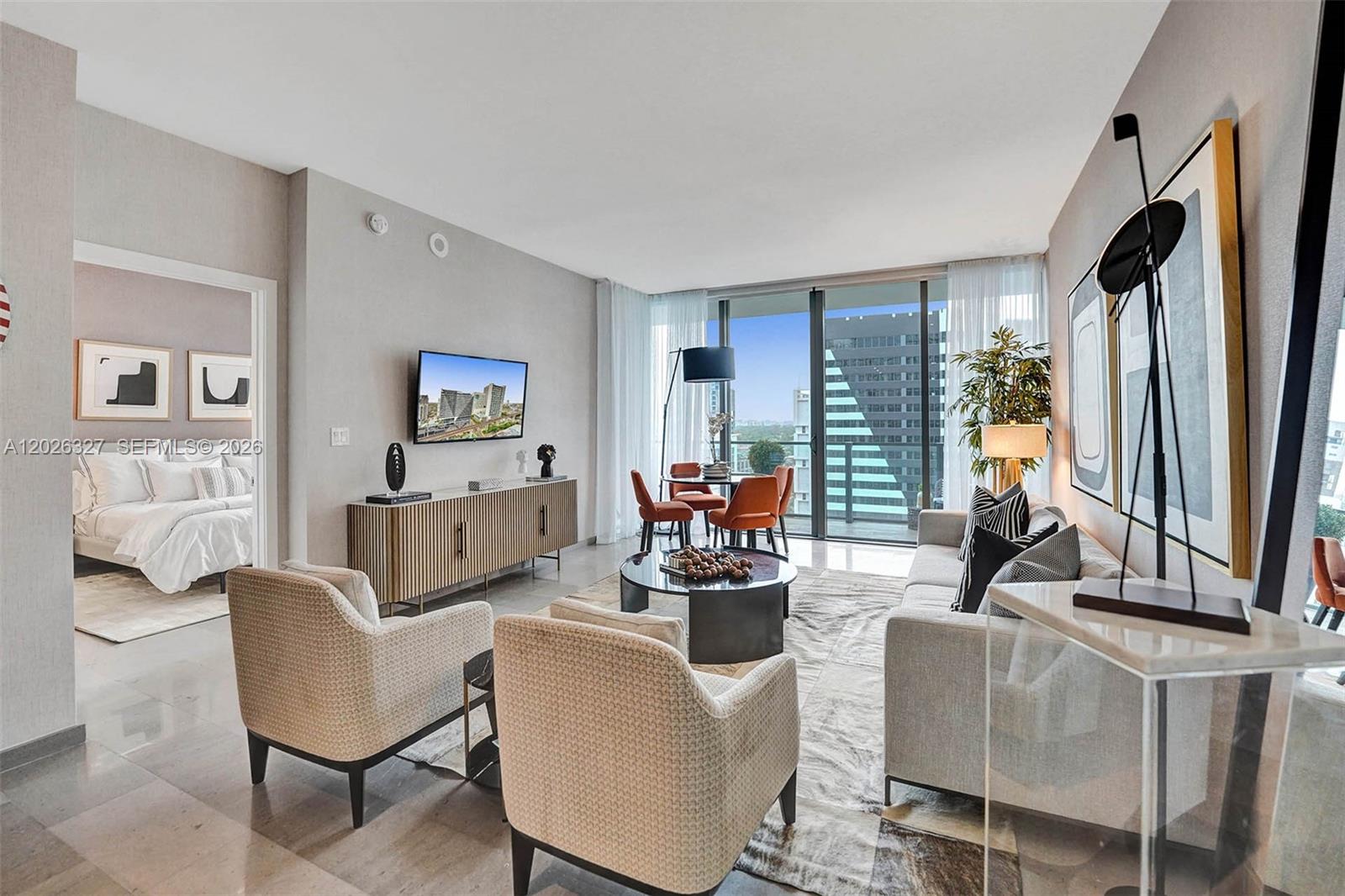 A modern living room features a sofa, two armchairs, a dining area, and floor-to-ceiling windows — 88 SW 7th St # 1408, Miami FL 33130, MIAMI, FL