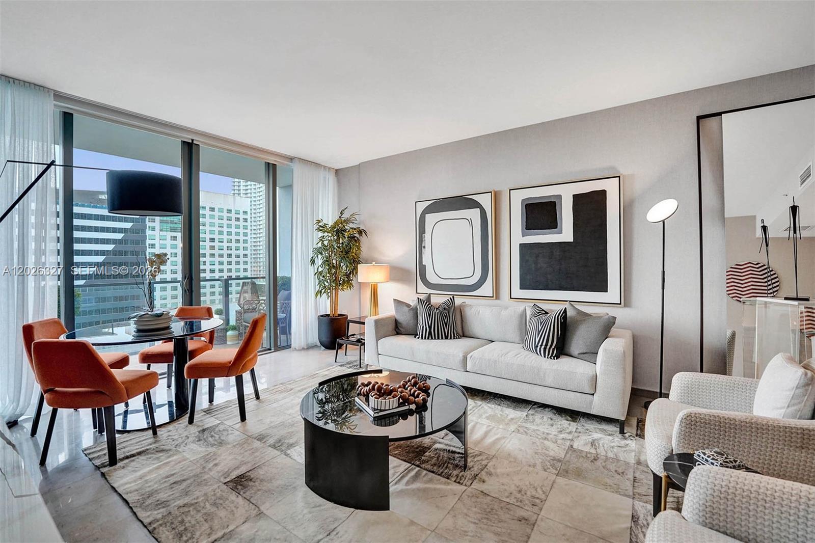 A modern living room features a grey sofa, orange dining chairs, and floor-to-ceiling windows — 88 SW 7th St # 1408, Miami FL 33130, MIAMI, FL