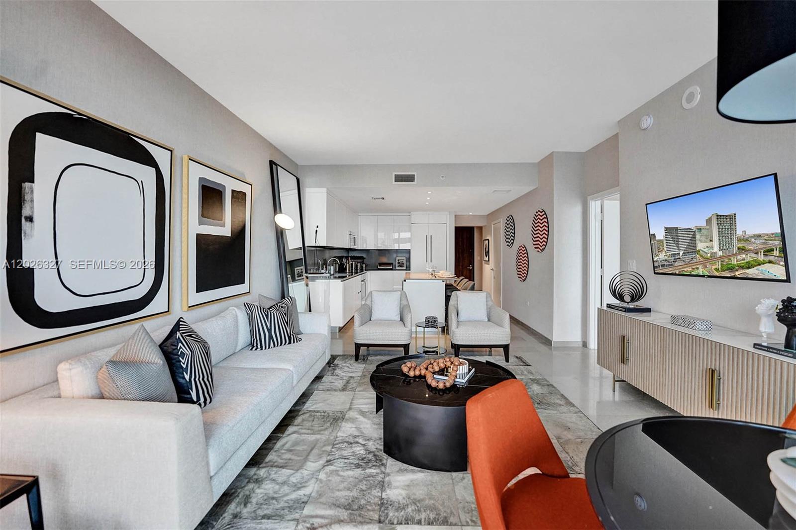 A modern living room features a light gray sofa, two armchairs, and an open kitchen — 88 SW 7th St # 1408, Miami FL 33130, MIAMI, FL