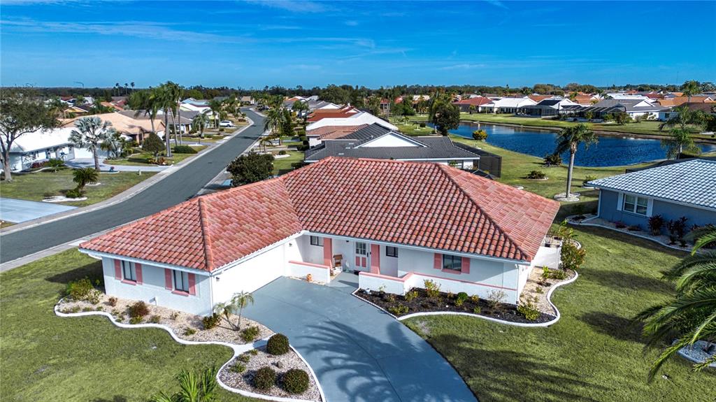 An aerial view of a single-story house with a red tile roof and driveway — 1853 WOLF LAUREL DRIVE, SUN CITY CENTER, FL
