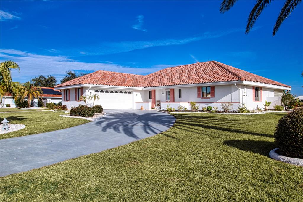 A single-story white house with a red tile roof and a curved concrete driveway — 1853 WOLF LAUREL DRIVE, SUN CITY CENTER, FL