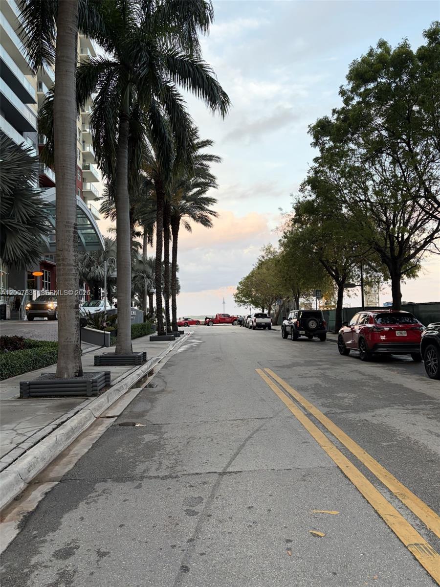 A street lined with palm trees and parked cars leads toward the horizon — 1155 Brickell Bay Dr # 1201, Miami FL 33131, MIAMI, FL