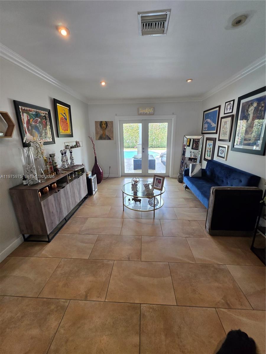 A living room features tile flooring, a blue sofa, a glass coffee table, and patio doors — 8620 SW 85th Ave, Miami FL 33143, MIAMI, FL