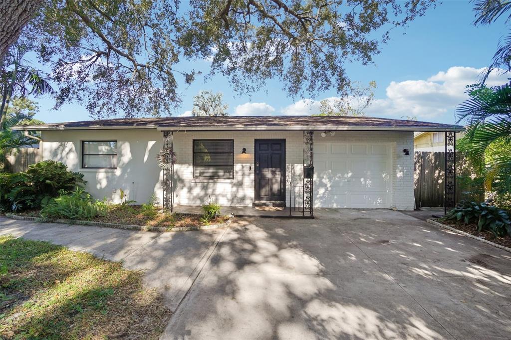 A single-story house with a white brick facade, a front-facing garage, and a concrete driveway — 162 SE LINCOLN CIRCLE N, ST PETERSBURG, FL