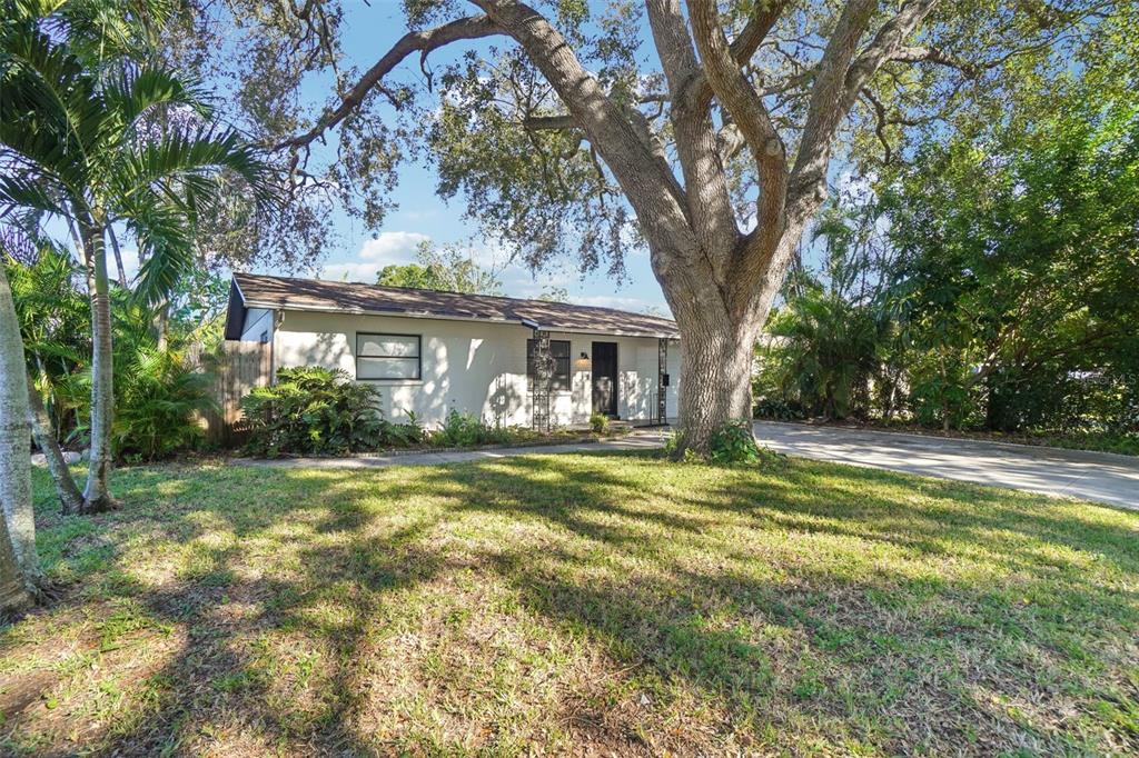 A single-story house with a large oak tree in the front yard and a driveway — 162 SE LINCOLN CIRCLE N, ST PETERSBURG, FL