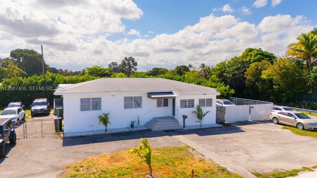 A white, single-story house with a flat roof sits on a paved lot with cars — 5290 Palm Ave, Hialeah FL 33012, HIALEAH, FL