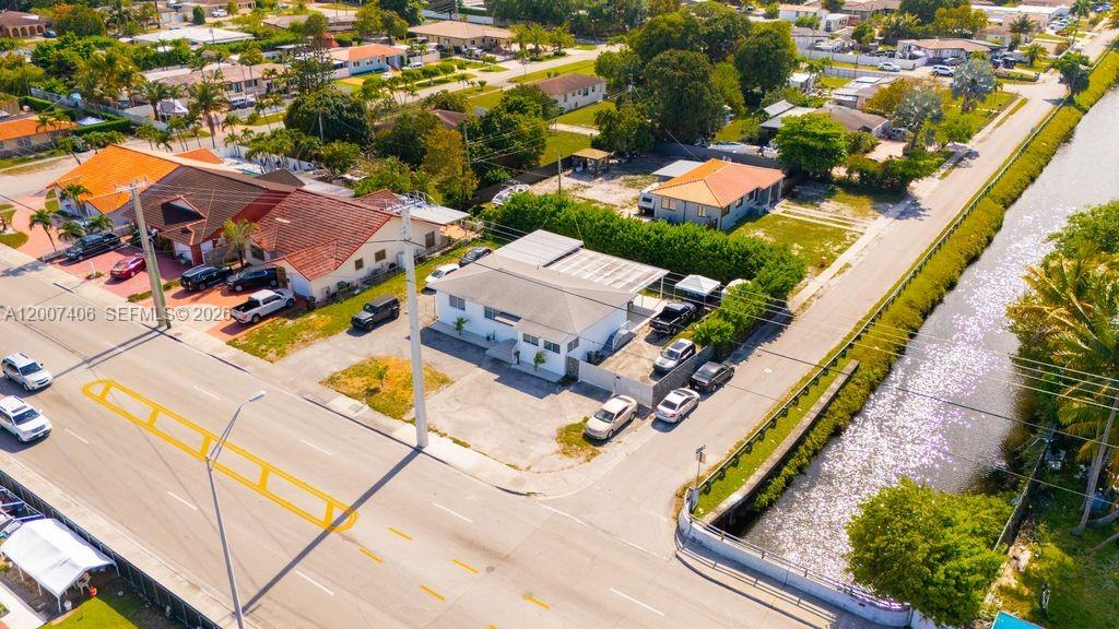 An aerial view shows a residential property with a canal and street in the foreground — 5290 Palm Ave, Hialeah FL 33012, HIALEAH, FL