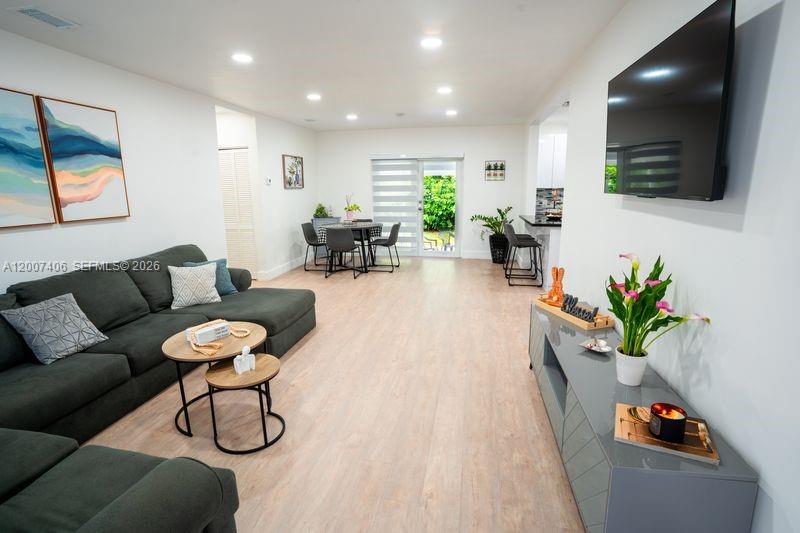 A living room features a dark gray sectional sofa, a dining area, and a wall-mounted television — 5290 Palm Ave, Hialeah FL 33012, HIALEAH, FL
