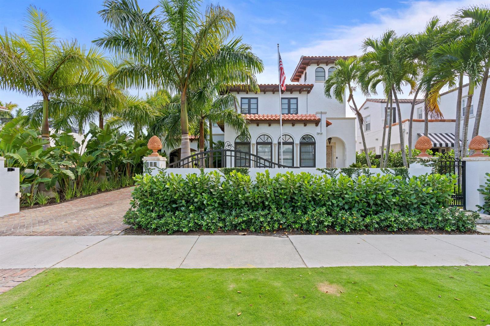 A white Mediterranean-style house with a tile roof, arched windows, and lush landscaping — 112 Roosevelt Place, West Palm Beach FL 33405, WEST PALM BEACH, FL