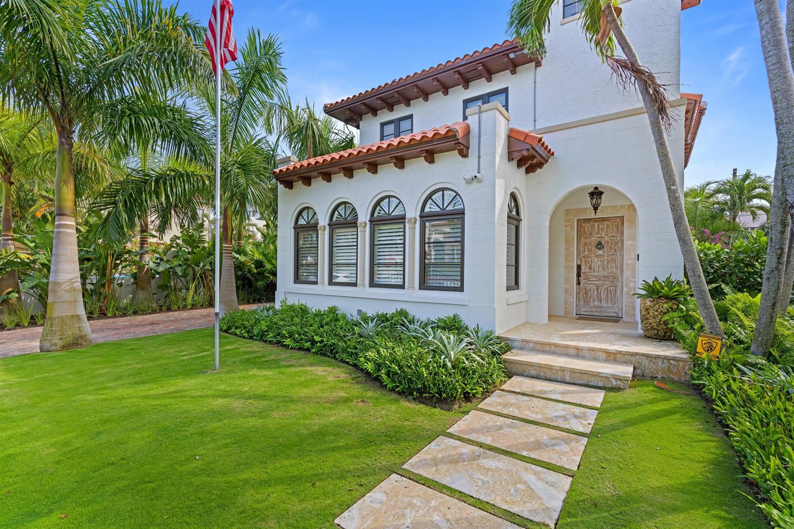 A white Mediterranean-style house features a tiled roof, arched windows, and a stone walkway — 112 Roosevelt Place, West Palm Beach FL 33405, WEST PALM BEACH, FL