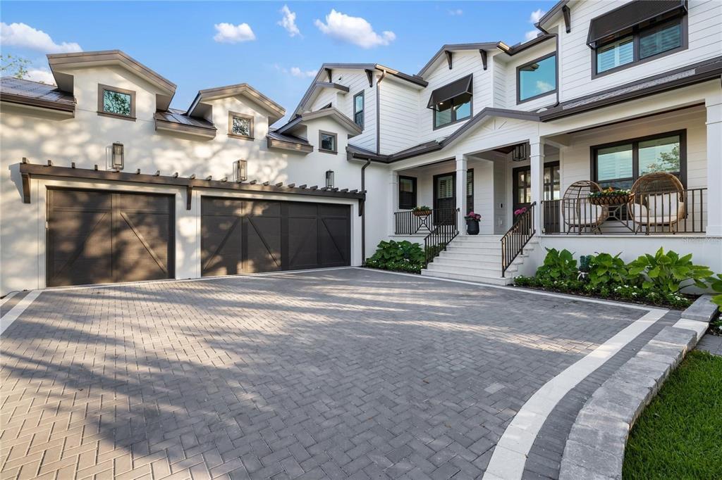 A modern white house with a three-car garage and a paved driveway — 4634 HIGEL AVENUE, SARASOTA, FL