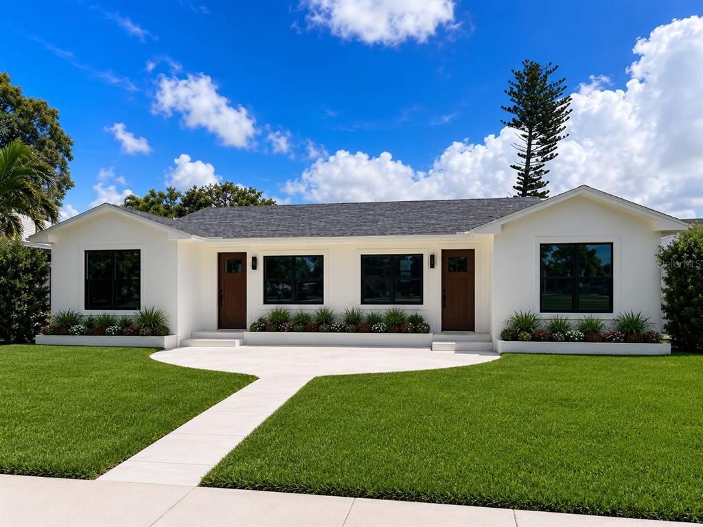 A white single-story house with a dark roof, two brown doors, and a front lawn — 3219 E DE BAZAN AVENUE, ST PETERSBURG, FL