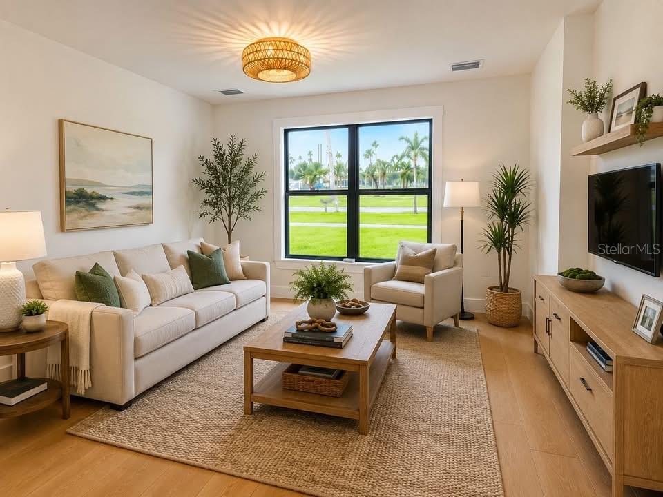 A living room features a beige sofa, wooden coffee table, and large window with outdoor views — 3219 E DE BAZAN AVENUE, ST PETERSBURG, FL