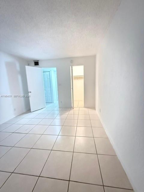 An empty room features white walls, a tiled floor, and two open doorways — 4550 NW 9th St # 812E, Miami FL 33126, MIAMI, FL