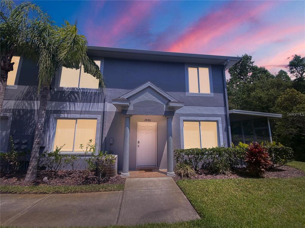 A two-story gray house with a covered entryway, columns, and a concrete walkway — 18181 PARADISE POINT DRIVE, TAMPA, FL