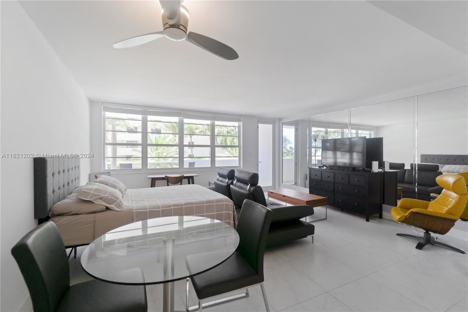 A studio apartment features a bed, dining set, sofa, and a yellow lounge chair — 100 Lincoln Rd # 436, Miami Beach FL 33139, MIAMI BEACH, FL