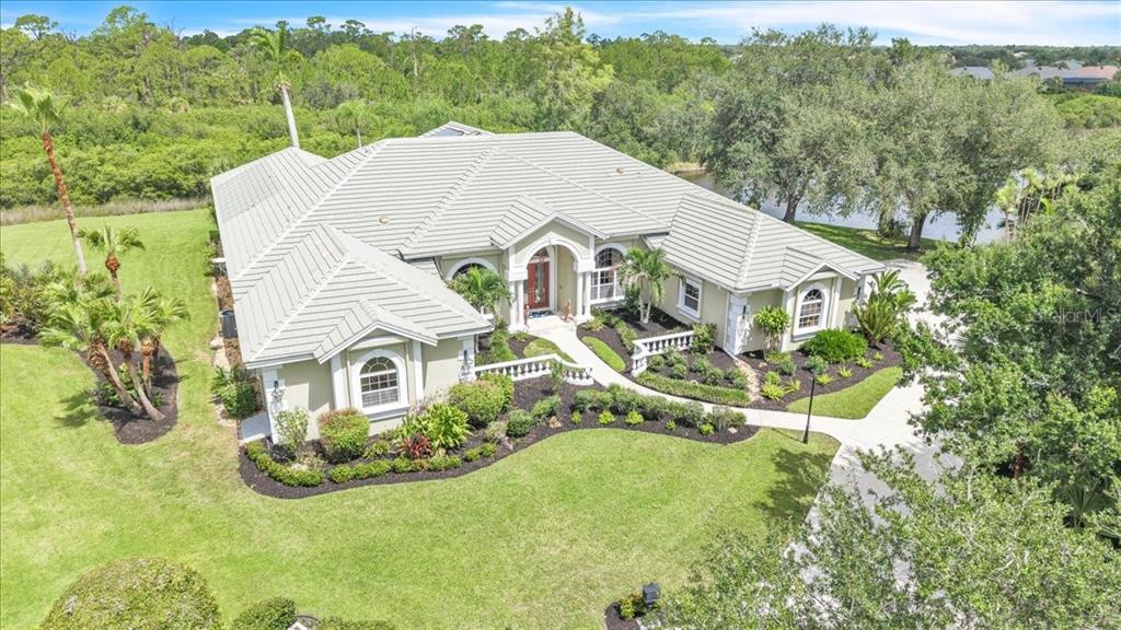 An aerial view of a single-story house with a light-colored roof and landscaped yard — 3001 RIVERSHORE LANE, PORT CHARLOTTE, FL