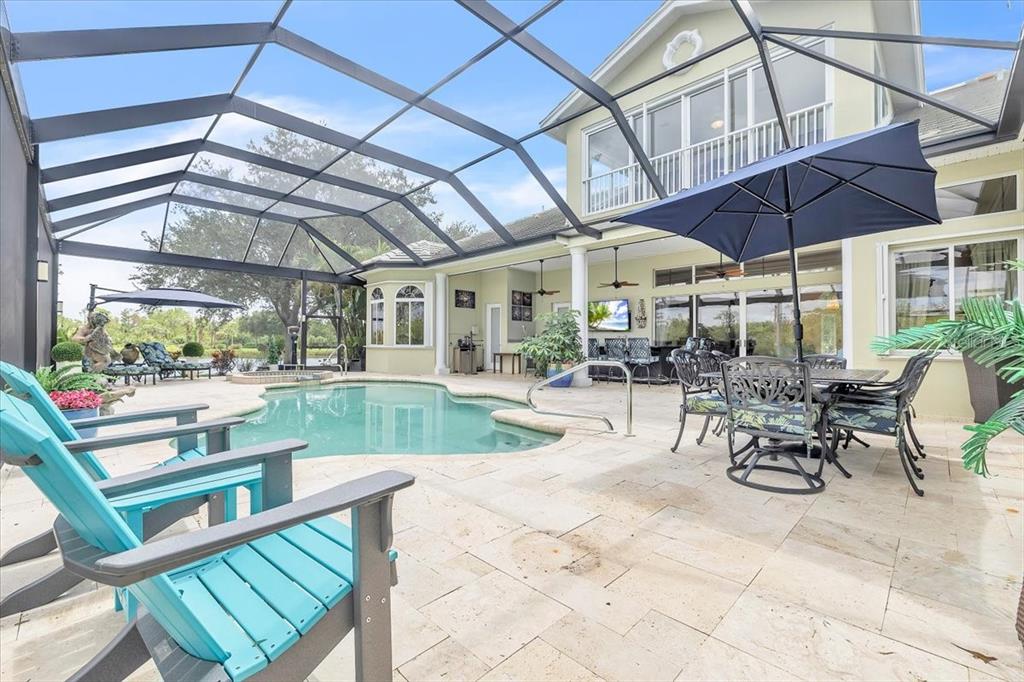 A screened-in patio features a swimming pool, outdoor dining furniture, and a two-story house exterior — 3001 RIVERSHORE LANE, PORT CHARLOTTE, FL