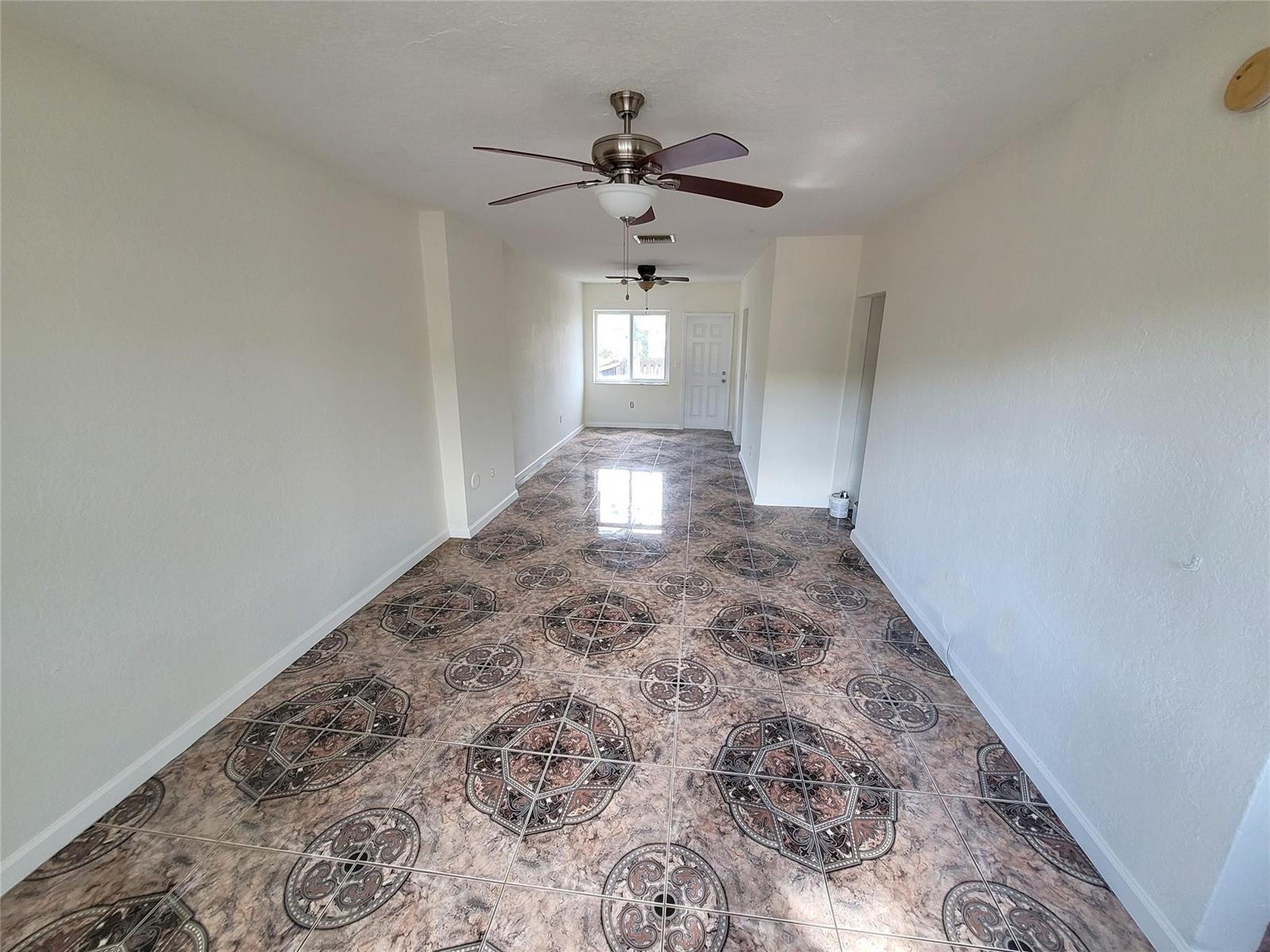 An empty room features white walls, a ceiling fan, and patterned brown tile flooring — 8451 NW 4th Avenue # 8451, Miami FL 33150, MIAMI, FL
