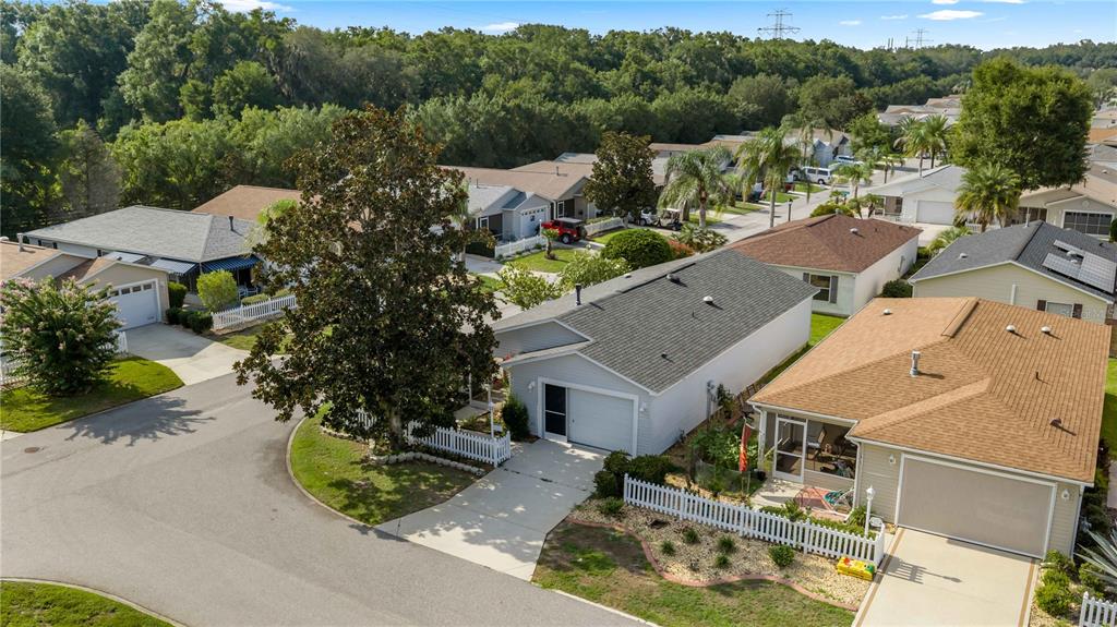 An aerial view of a suburban neighborhood featuring several single-story houses with driveways and lawns — 272 EMMALEE PLACE, THE VILLAGES, FL