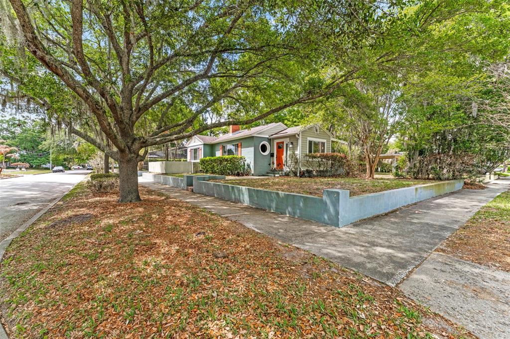 A single-story house with a green exterior, orange front door, and a low concrete wall — 600 VASSAR STREET, ORLANDO, FL