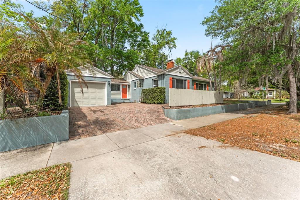 A single-story house with a blue exterior, orange door, and a brick driveway — 600 VASSAR STREET, ORLANDO, FL