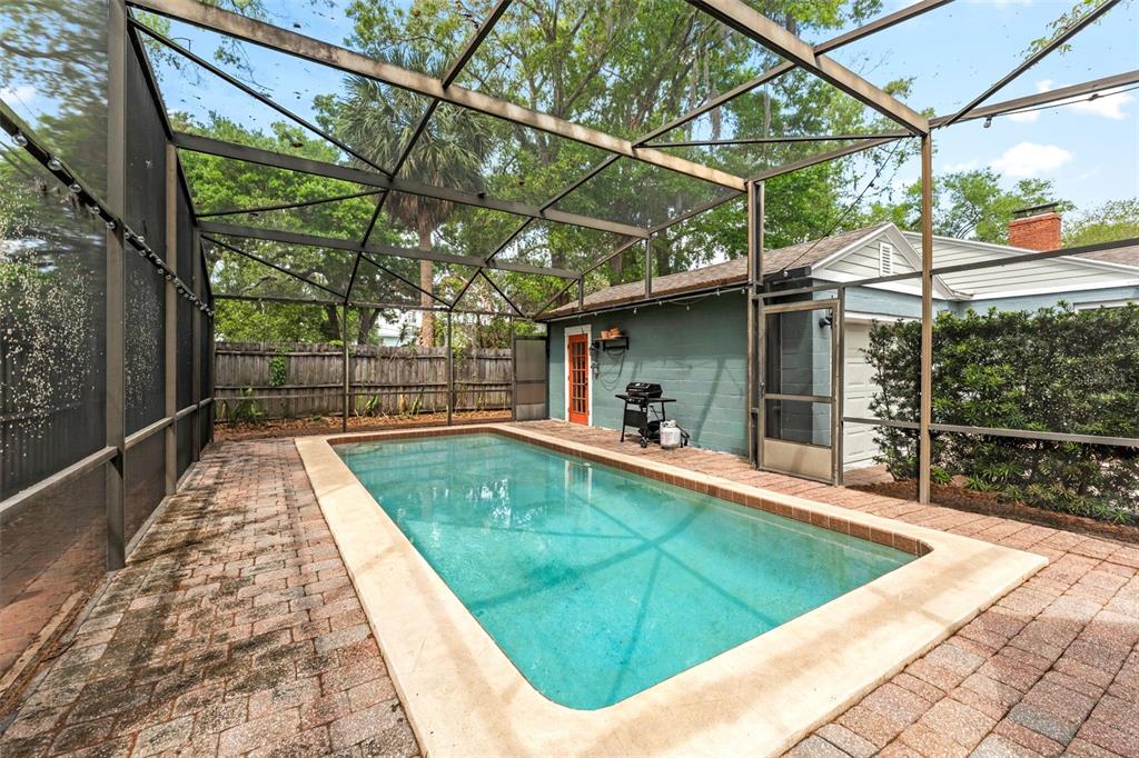 A rectangular swimming pool is enclosed by a screened lanai with brick pavers — 600 VASSAR STREET, ORLANDO, FL