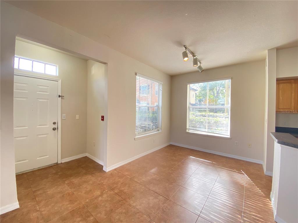 An empty dining area features tile flooring, two windows with blinds, and a ceiling light fixture — 6025 WESTGATE DRIVE UNIT 2512, ORLANDO, FL