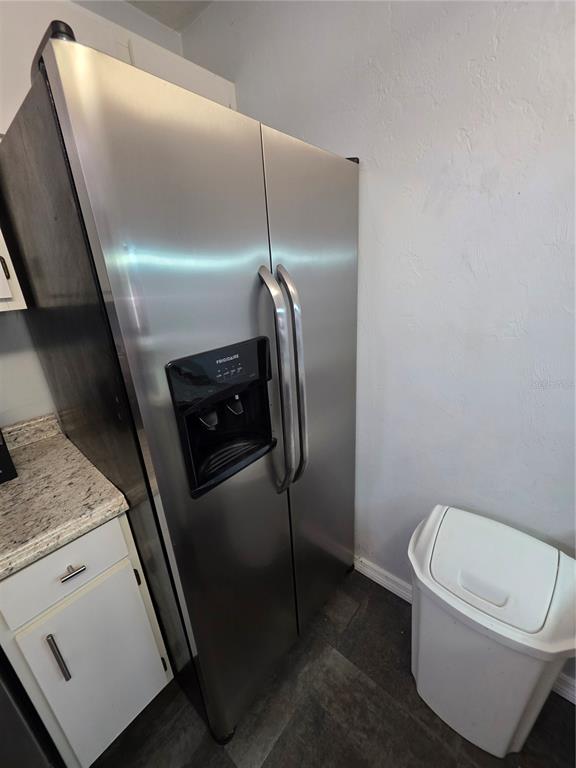 A stainless steel side-by-side refrigerator stands next to a white trash can in a kitchen — 4000 SW 23RD STREET UNIT 6-305, GAINESVILLE, FL