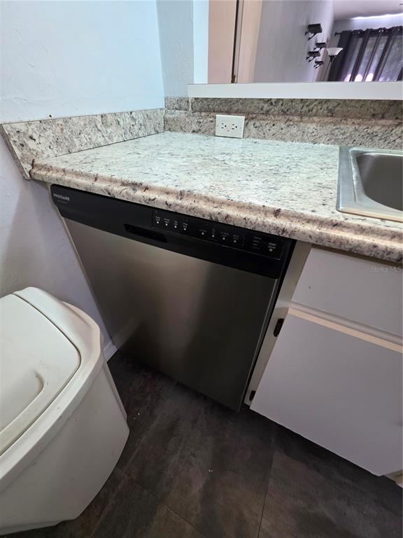 A stainless steel Frigidaire dishwasher is installed under a granite countertop in a kitchen — 4000 SW 23RD STREET UNIT 6-305, GAINESVILLE, FL