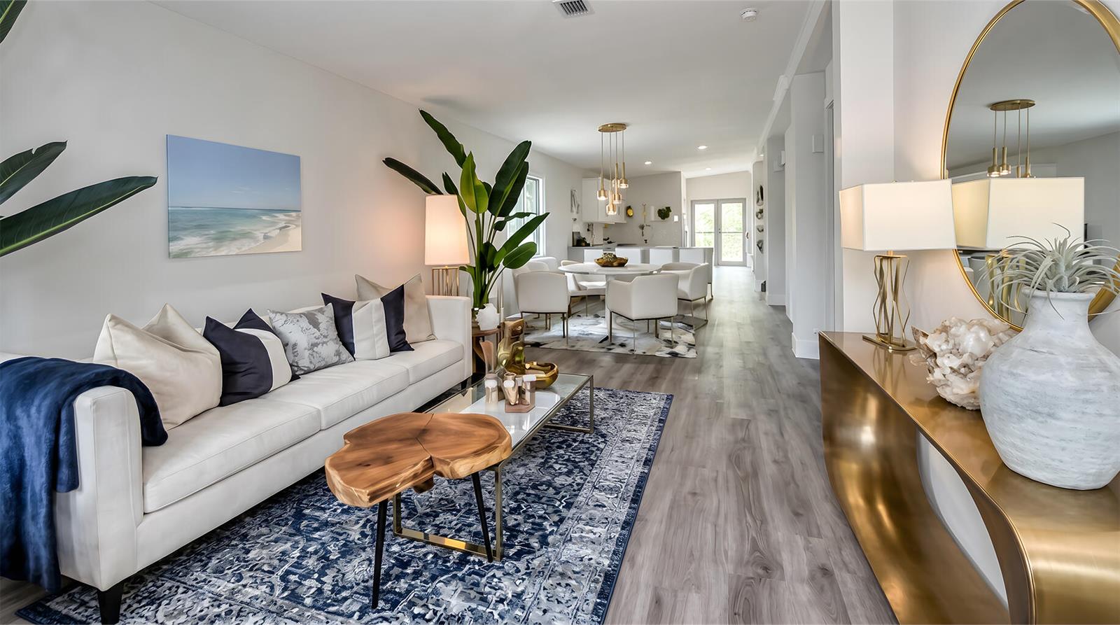 A bright living room features a white sofa, blue rug, and a gold console table — 8019 NW 8th Avenue, Miami FL 33150, MIAMI, FL