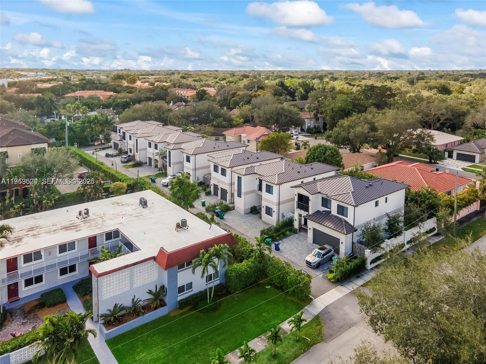 An aerial view shows a row of modern townhouses next to an older apartment building — 7771 SW 99th St, Miami FL 33156, MIAMI, FL
