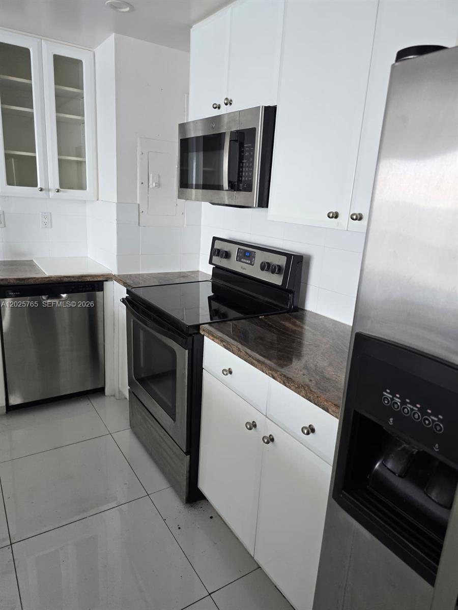 A kitchen features white cabinets, stainless steel appliances, and dark granite countertops — 11111 Biscayne Blvd # 17D, Miami FL 33181, MIAMI, FL