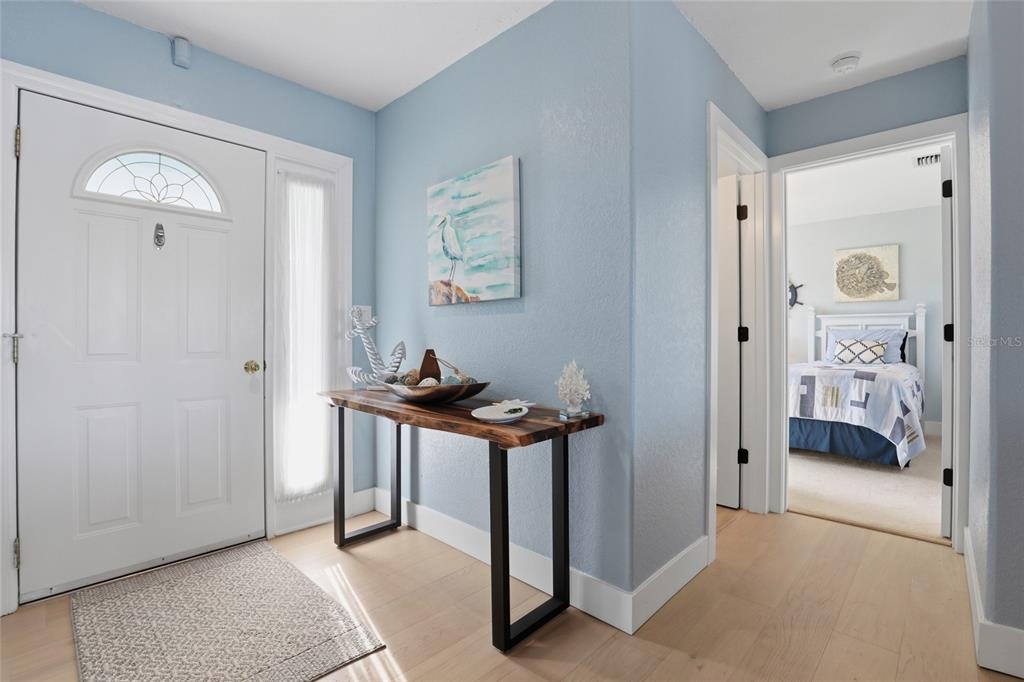 A light blue entryway features a wooden console table, a white door, and light flooring — 414 SPRING LAKE BOULEVARD NW, PORT CHARLOTTE, FL