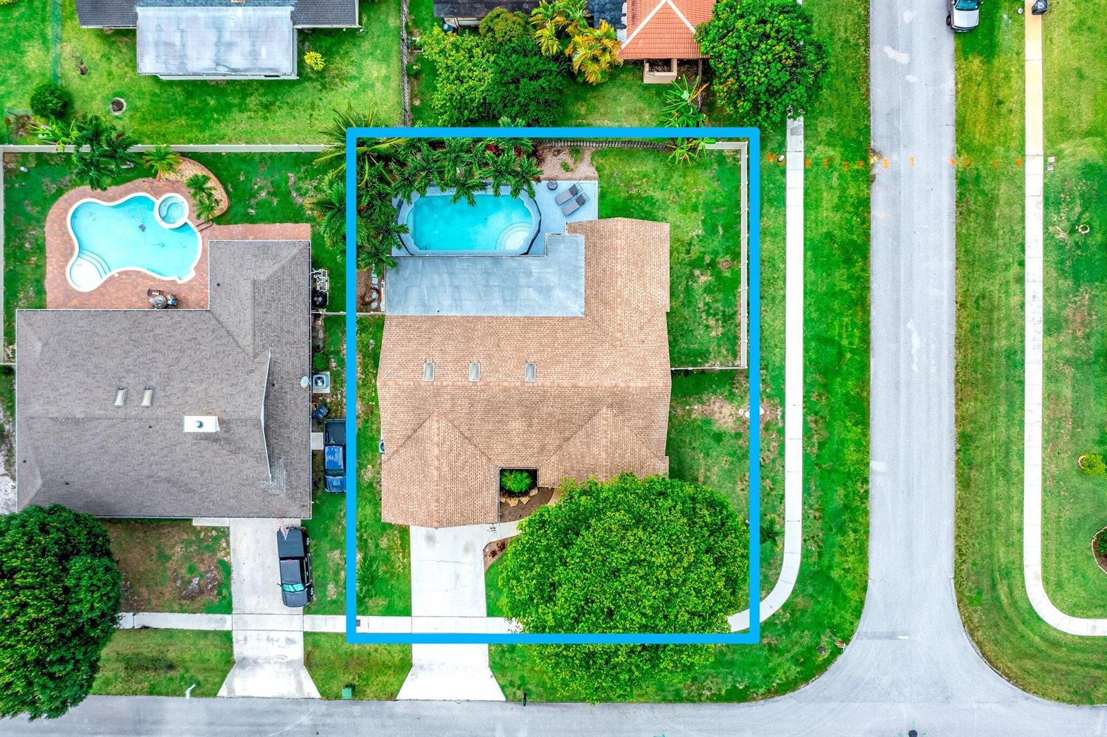 An aerial view of a suburban house with a swimming pool and a large tree — 574 Juniper Place, Wellington FL 33414, WELLINGTON, FL