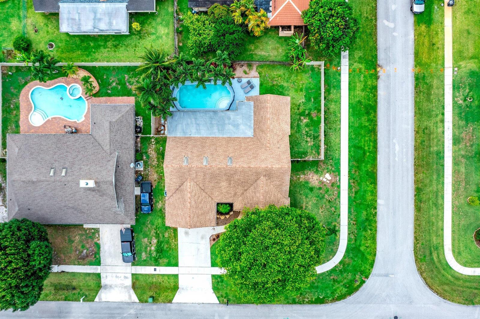 An aerial view shows two adjacent suburban houses with swimming pools and large green lawns — 574 Juniper Place, Wellington FL 33414, WELLINGTON, FL