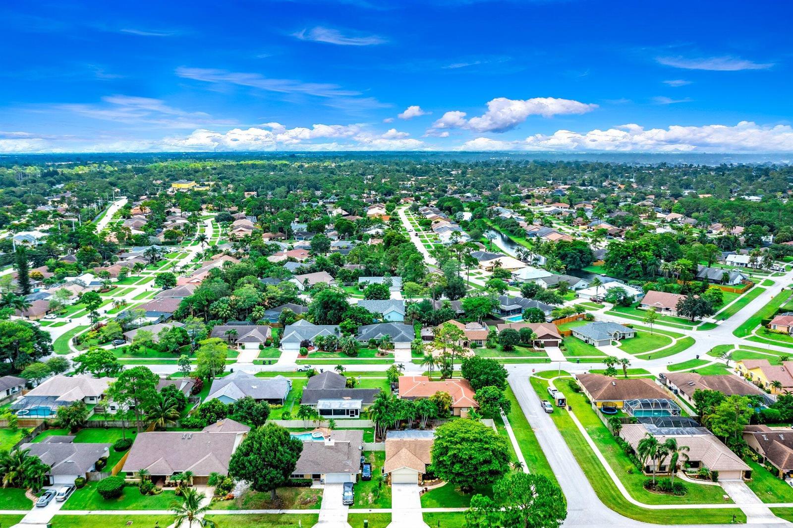 An aerial view of a suburban neighborhood with single-family homes, green lawns, and mature trees — 574 Juniper Place, Wellington FL 33414, WELLINGTON, FL
