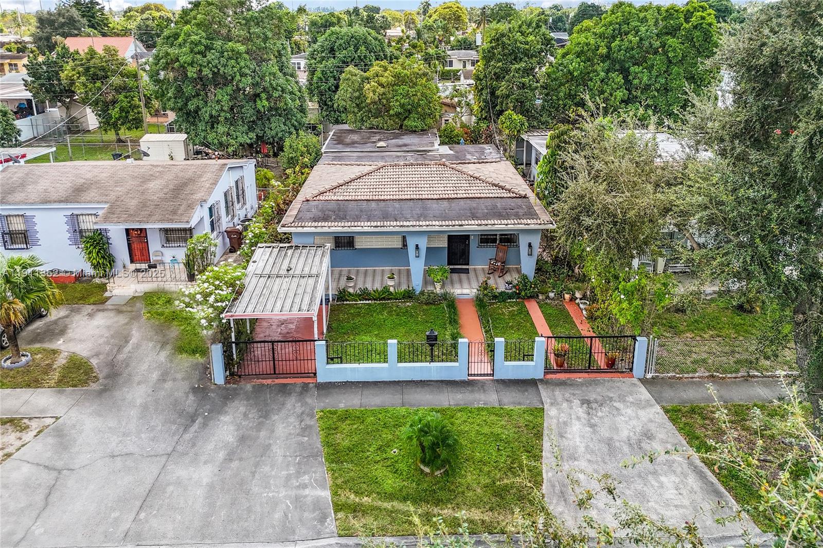 An aerial view shows a blue house with a tiled roof and a metal carport — 682 W 37th St, Hialeah FL 33012, HIALEAH, FL