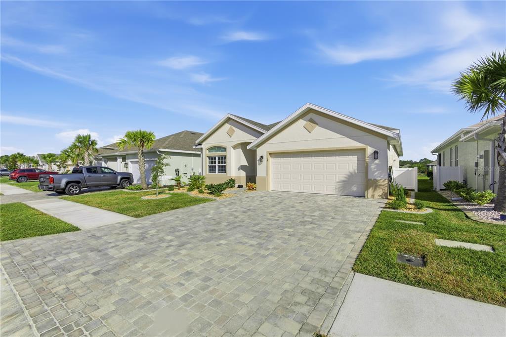 A single-story suburban house with a paved driveway, two-car garage, and a landscaped front yard — 14 MATANZAS LAKES DRIVE, PALM COAST, FL