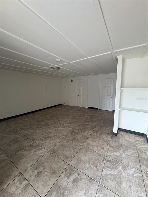 An empty room with tiled floors, a drop ceiling, and two white interior doors — 14846 17TH STREET, DADE CITY, FL