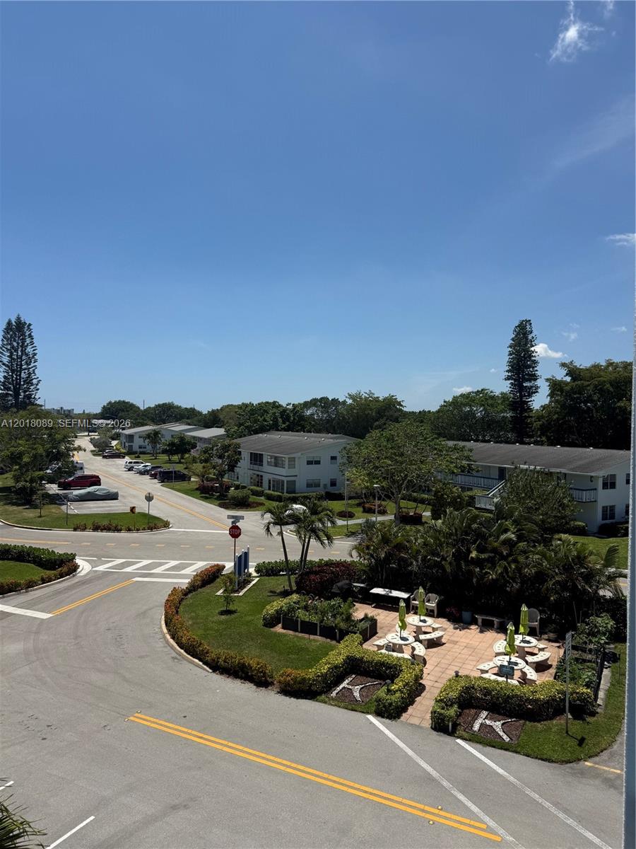 An elevated view of a residential complex with parking, landscaping, and a patio area — 4047 Lyndhurst K # 4047, Deerfield Beach FL 33442, DEERFIELD BEACH, FL