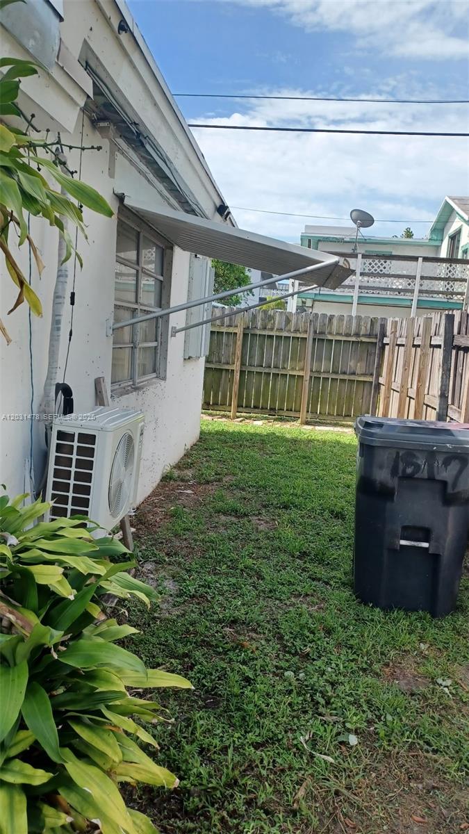A side yard features a white exterior wall, a window awning, and an air conditioning unit — 1806 Funston St # B, Hollywood FL 33020, HOLLYWOOD, FL