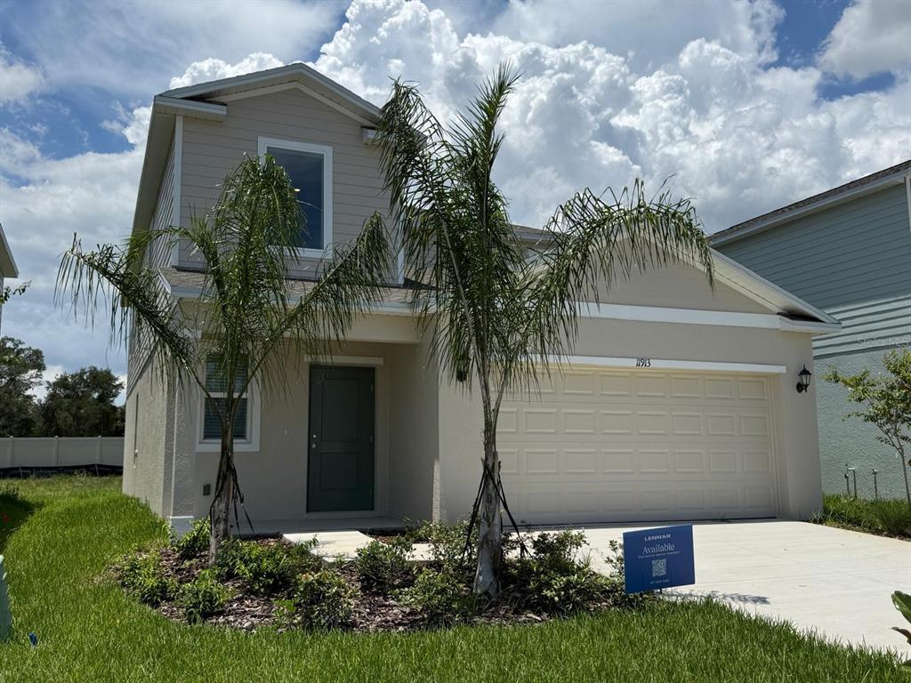 A two-story suburban house with a beige exterior, a two-car garage, and two palm trees — 11913 NOBLE CHASE PATH, DADE CITY, FL