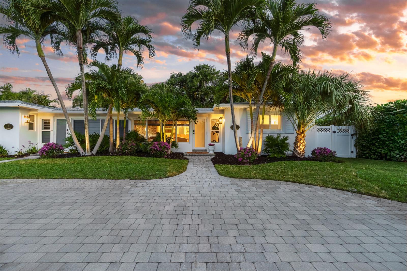 A single-story white house with a paved driveway and palm trees at sunset — 7 Fayette Drive, Boynton Beach FL 33435, BOYNTON BEACH, FL