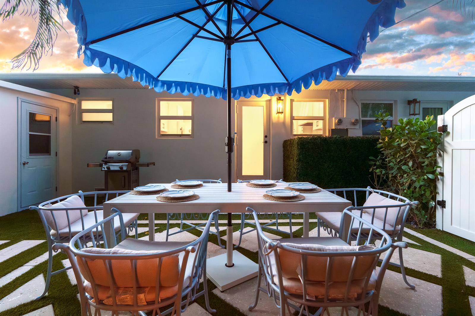 A patio features a dining set under a blue umbrella on a paved lawn area — 7 Fayette Drive, Boynton Beach FL 33435, BOYNTON BEACH, FL