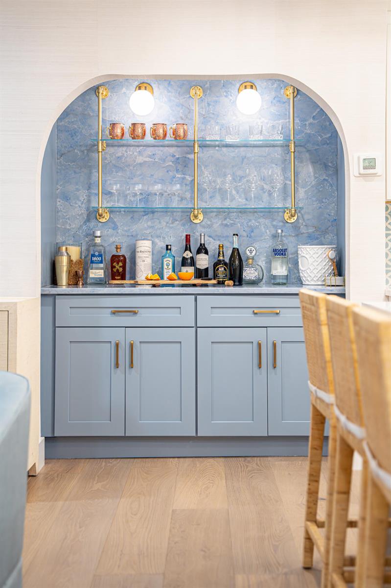 A blue built-in wet bar features glass shelving, gold hardware, and a marble-patterned backsplash — 7 Fayette Drive, Boynton Beach FL 33435, BOYNTON BEACH, FL