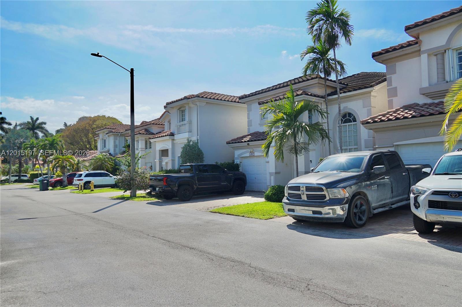A row of two-story suburban houses with driveways and parked pickup trucks — 10913 NW 67th St, Doral FL 33178, DORAL, FL