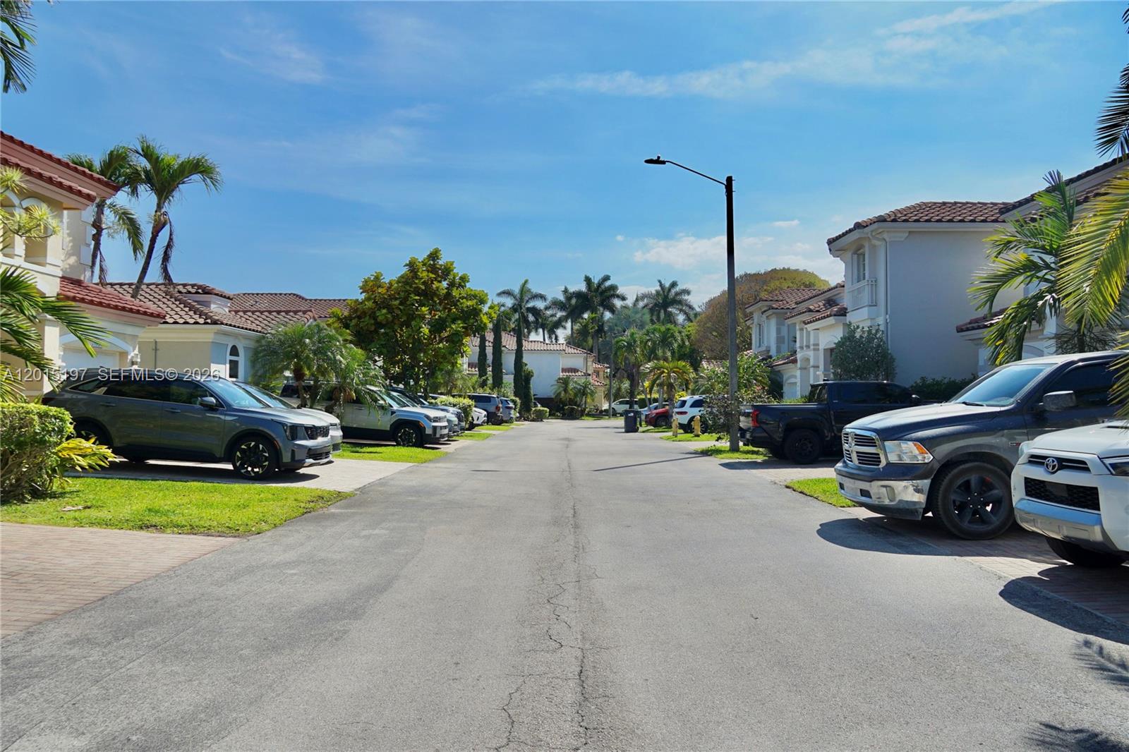 A residential street features parked cars in front of two-story homes with palm trees — 10913 NW 67th St, Doral FL 33178, DORAL, FL