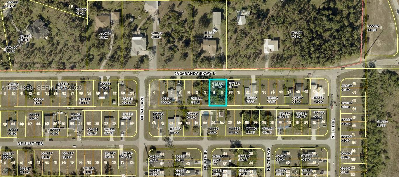An aerial view shows a single-family home with a pool and fenced yard on a lot — 614 Jacaranda Pkwy E, Cape Coral FL 33909, CAPE CORAL, FL
